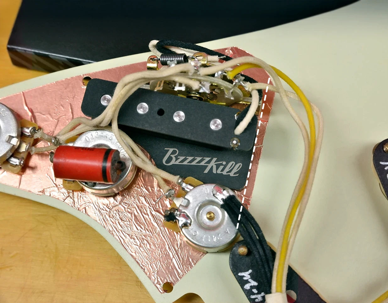 Placement of BzzzzKill device under pickguard.