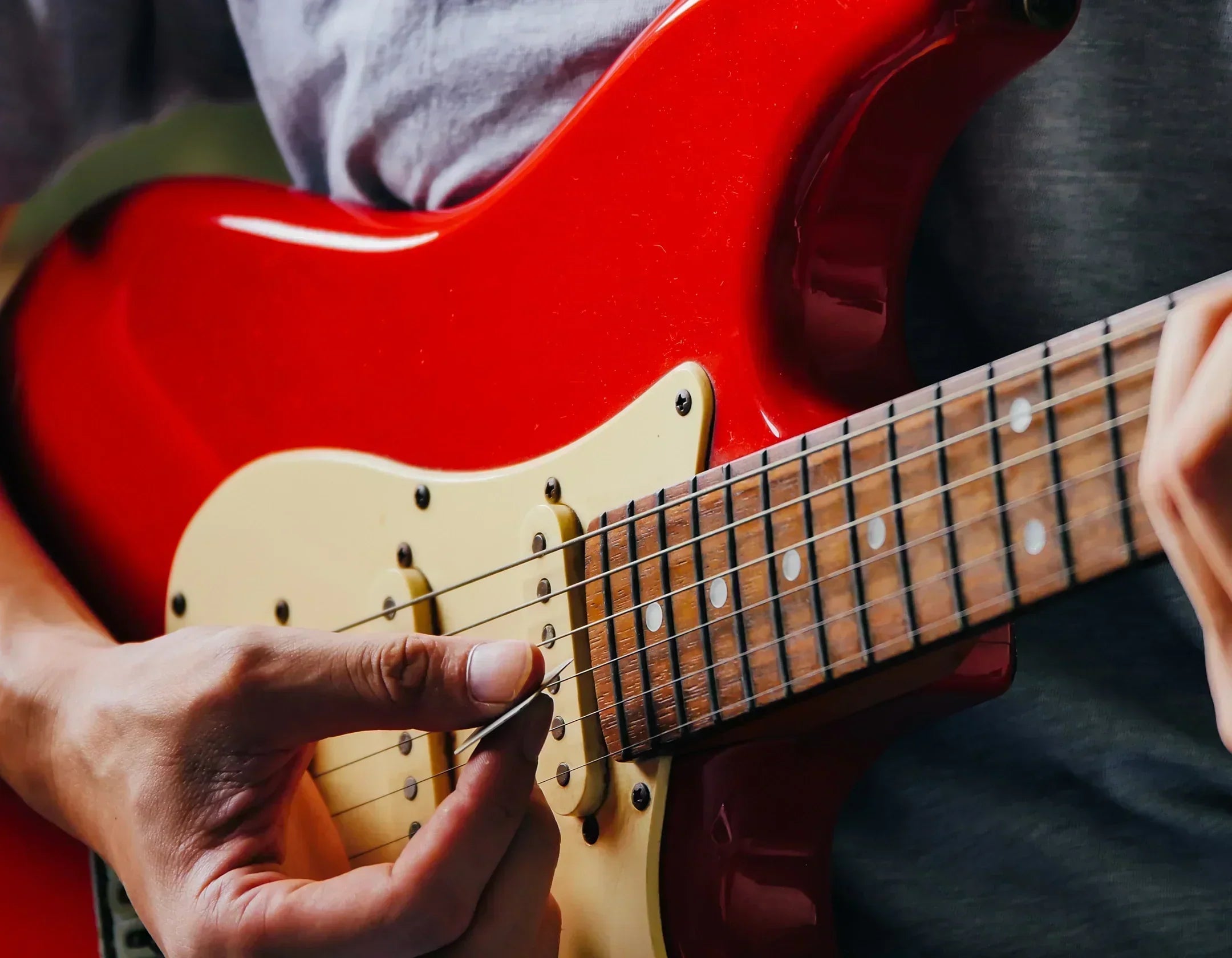 Close up of musician playing red Fender Stratocaster