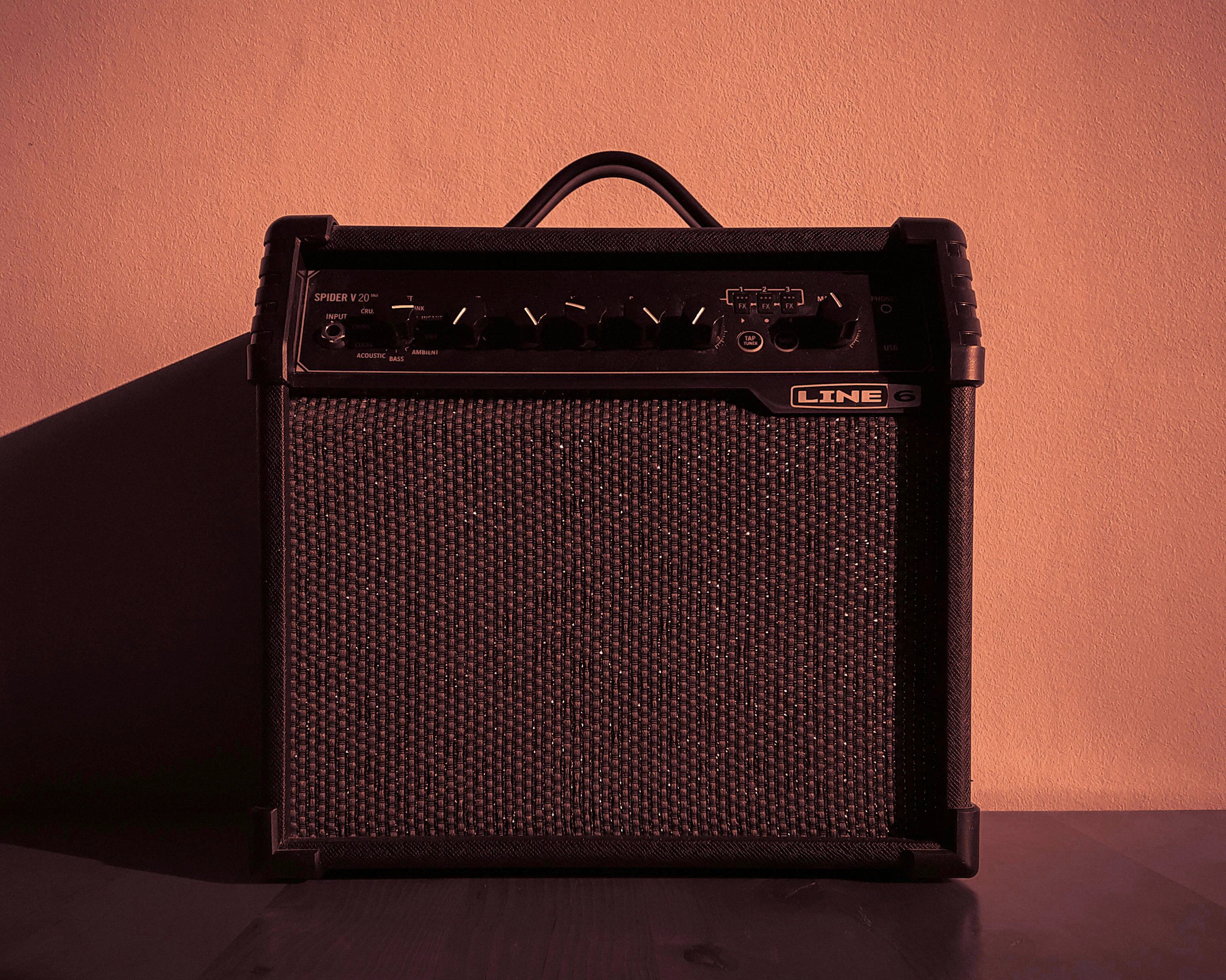 Black guitar amp on orange background.