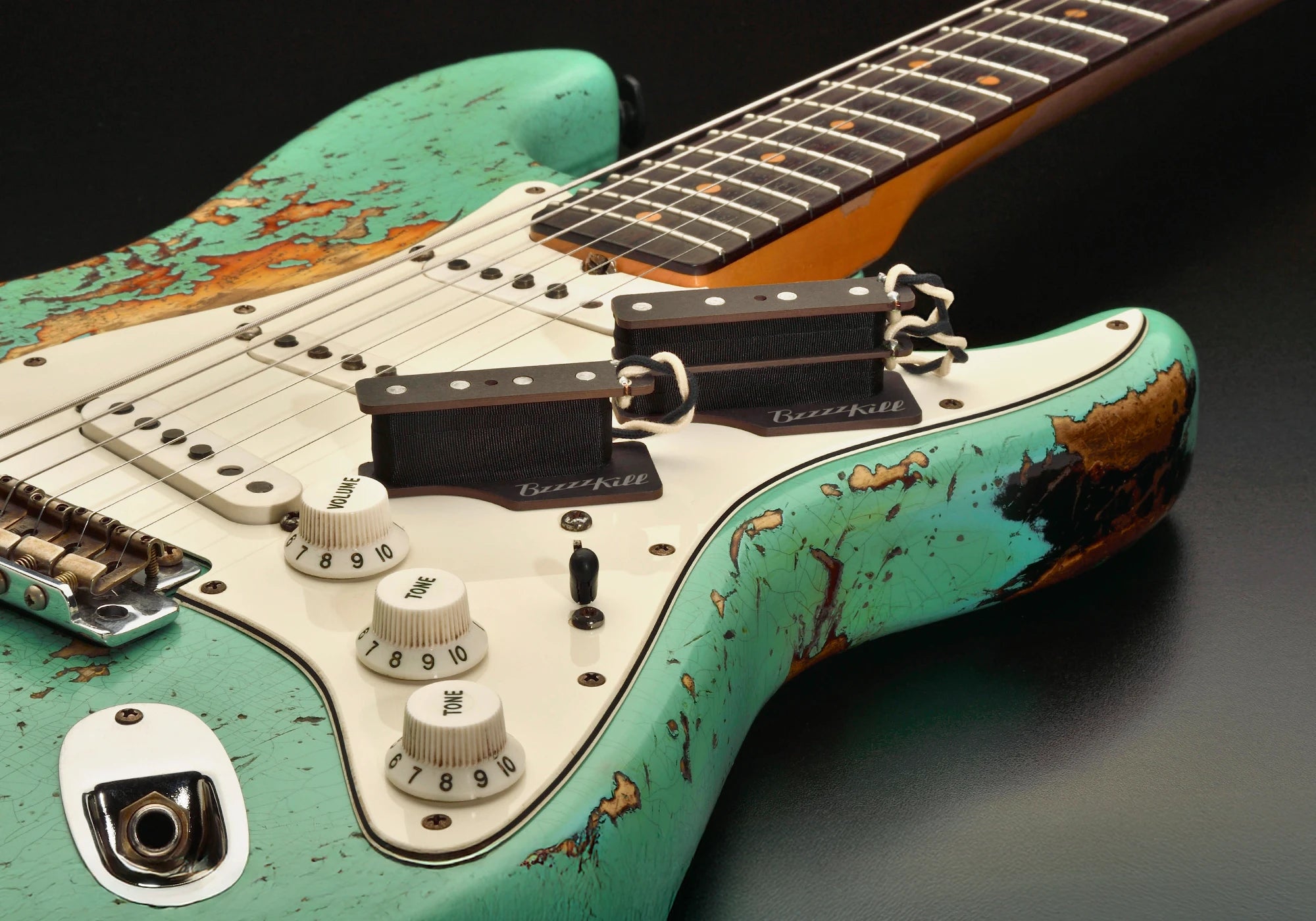 The BzzzzKill Dual and Single Layer devices for eliminating Fender Stratocaster 60 cycle hum in all pickup selector positions, on worn Turquoise Stratocaster.