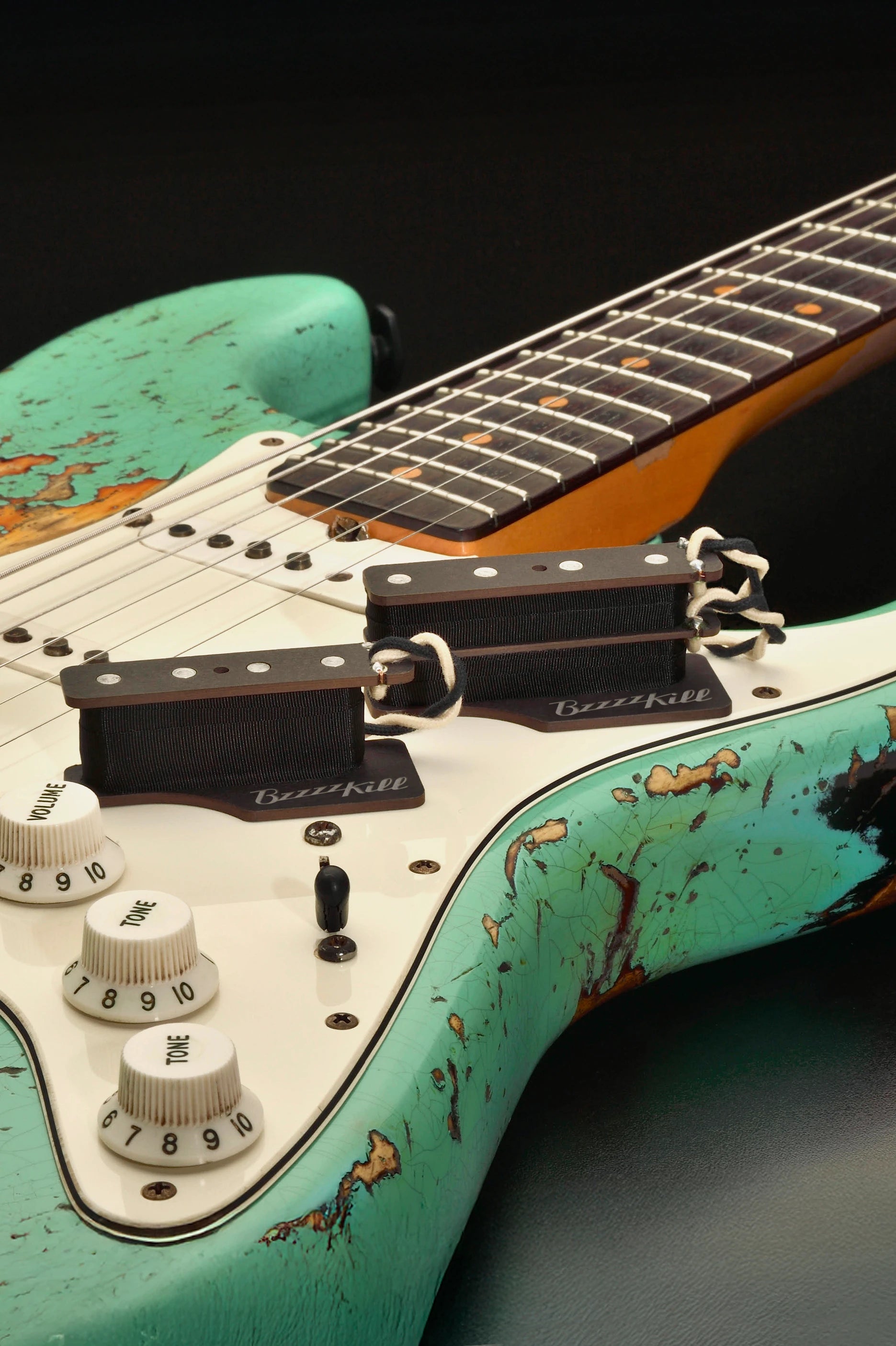The BzzzzKill Dual and Single Layer devices for eliminating Fender Stratocaster 60 cycle hum in all pickup selector positions, on worn Turquoise Stratocaster.