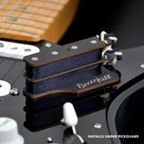 The BzzzzKill Dual Layer device for eliminating Fender Stratocaster 60 cycle hum in all pickup selector positions. Sitting on black Stratocaster. With text "Installs under pickguard".