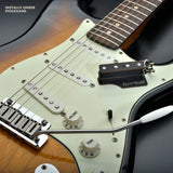 The BzzzzKill Dual Layer device for eliminating Fender Stratocaster 60 cycle hum in all pickup selector positions. Sitting on sunburst Stratocaster. With text "Installs under pickguard".