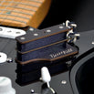 The BzzzzKill Dual Layer device for eliminating Fender Stratocaster 60 cycle hum in all pickup selector positions. Sitting on black Stratocaster.