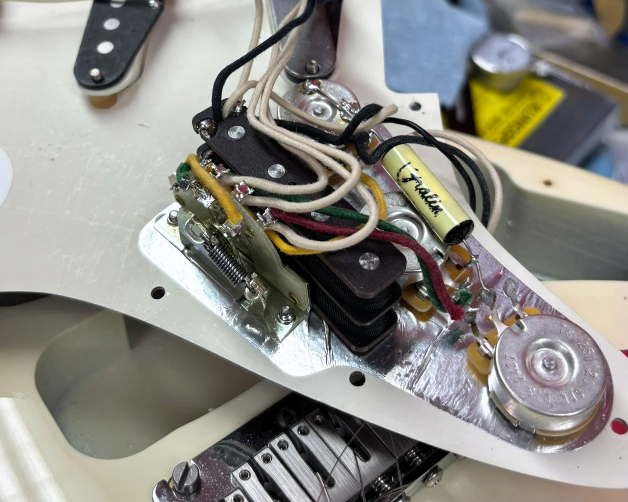 Installation placement of BzzzzKill device on opened backside of Fender Stratocaster pickguard.