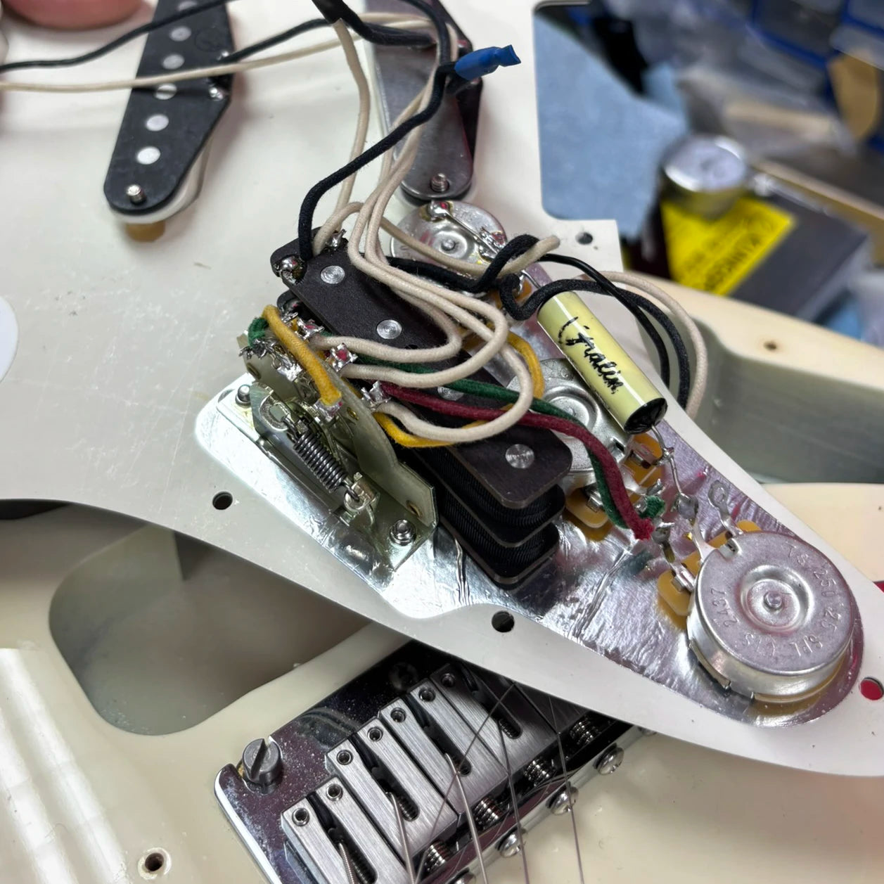 Installation placement of BzzzzKill device on opened backside of Fender Stratocaster pickguard.