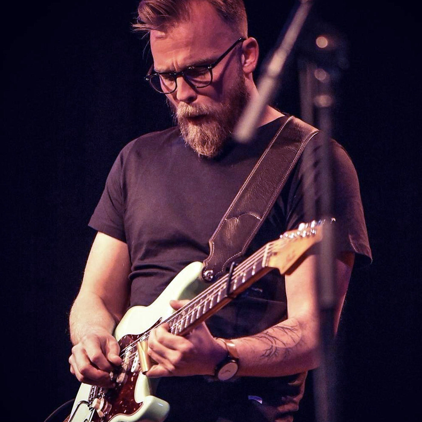 Musician Joey Landreth playing a Stratocaster guitar on stage.