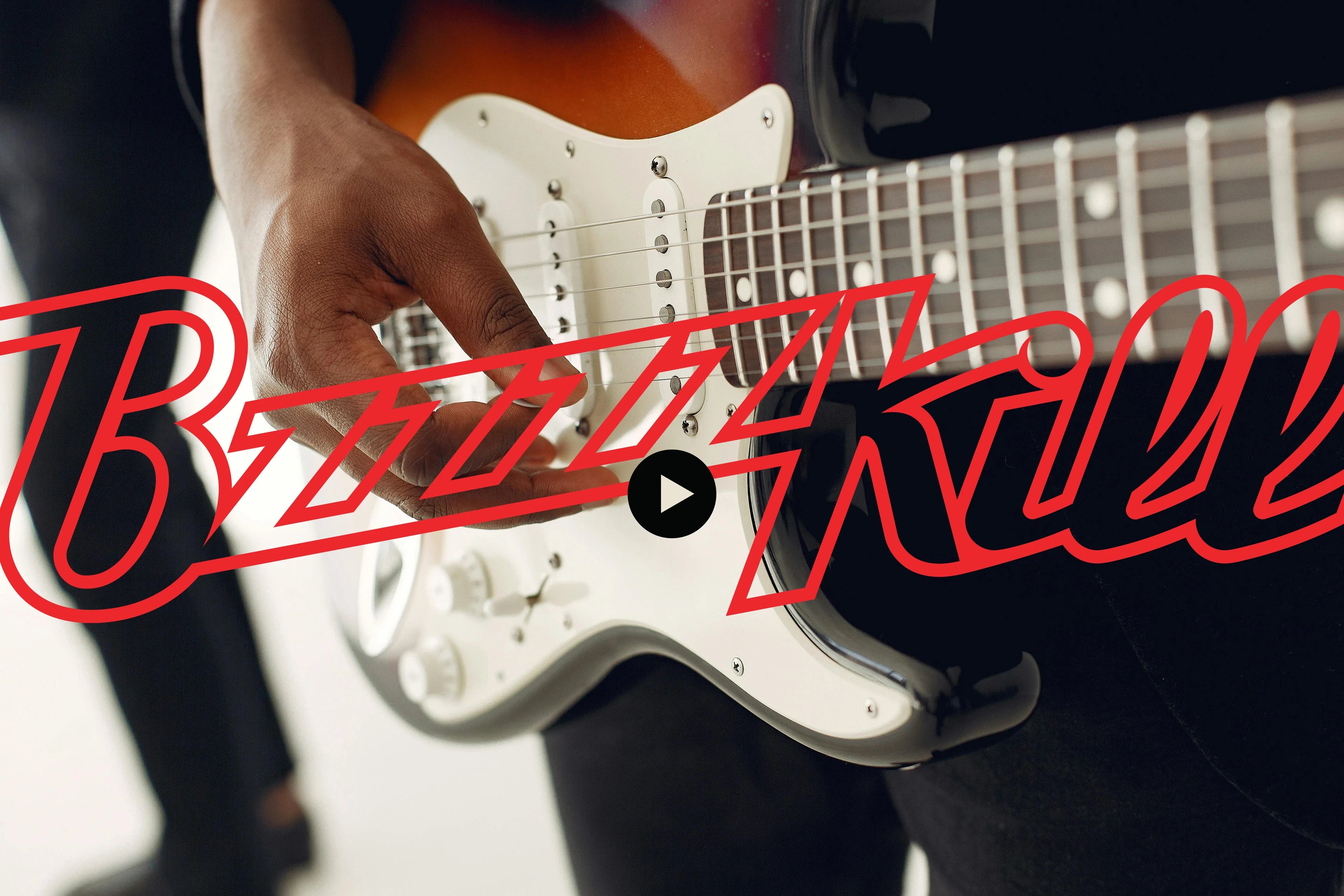 Close of hand playing Fender Stratocaster with BzzzzKill logo overlayed and video play button.
